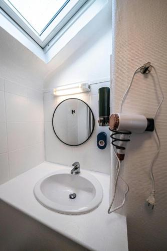 une salle de bain avec un lavabo et un miroir dans l'établissement Lescapade Blue and Yellow 10min to Paris, à Épinay-sur-Seine