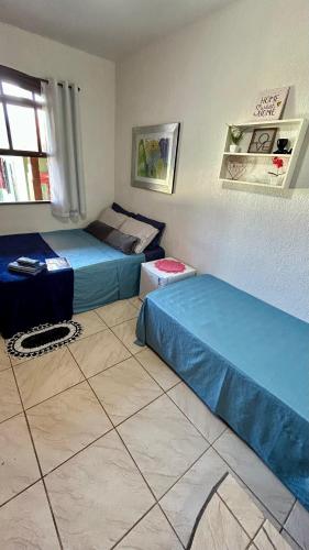 a room with two beds and a window in it at Pousada Aconchego de Maricá in Maricá