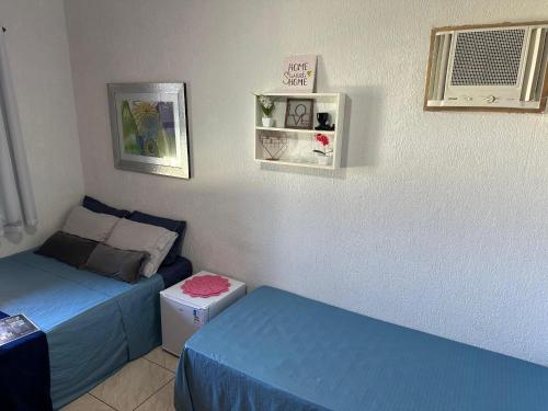 a small bedroom with two beds and a window at Pousada Aconchego de Maricá in Maricá