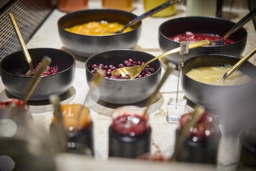a group of bowls of food with chop sticks in them at Designhotel Sonnhof by Vitus Winkler in Sankt Veit im Pongau