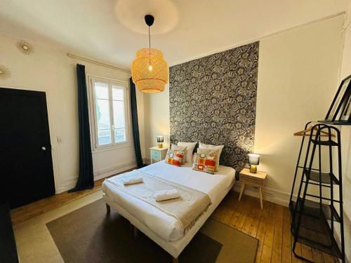 - une chambre avec un grand lit et un lustre dans l'établissement Le Prestigieux Ruinart - Centre-Ville, à Reims