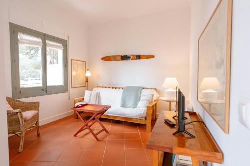 a bedroom with a bed and a table with a television at T5 · Cozy Retreat 50m to Beach Garden Escape in Tamariu