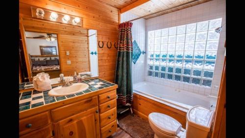 a bathroom with a sink and a tub and a toilet at Island Park Hideaway -Bill's Island -Hot Tub -BBQ in Island Park