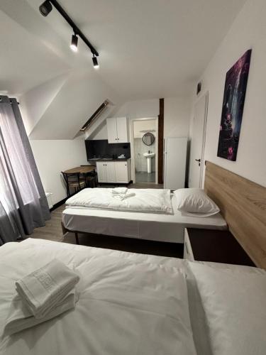 a room with two beds and a kitchen in it at La Conac Sibiu in Sibiu