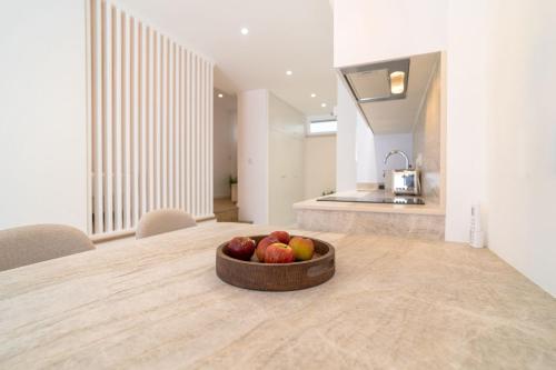a bowl of apples sitting on a table in a kitchen at Sónia's Studio in Nazaré