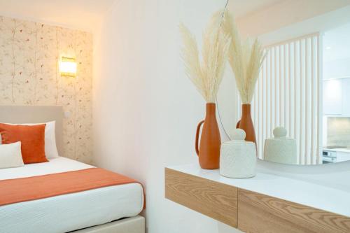a bedroom with a bed and vases on a shelf at Sónia's Studio in Nazaré
