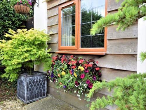 a window box with flowers on the side of a house at 1 bed in Bradford-on-Avon 58771 in Erlestoke