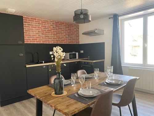 une table de salle à manger avec un vase de fleurs dessus dans l'établissement *La Factory / Saint Aignan, à Saint-Aignan