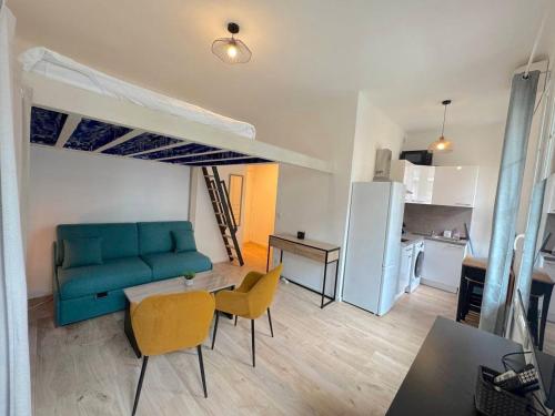 un salon avec un canapé bleu et une cuisine dans l'établissement Appartement élégant plage à 100m prom des anglais, à Nice