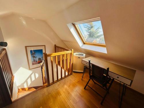 une chambre mansardée avec une lucarne et un bureau avec une chaise dans l'établissement Le Majestueux Brulée Hypercentre Parking, à Reims