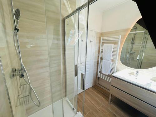 une salle de bain avec une douche, un lavabo et un miroir dans l'établissement Le Majestueux Brulée Hypercentre Parking, à Reims