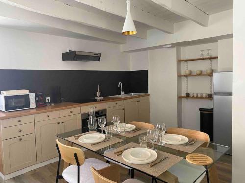 - une cuisine avec une table à manger, des assiettes et des verres à vin dans l'établissement *La Stracciatella / Saint-Aignan, à Saint-Aignan