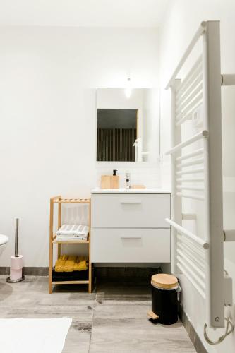 une salle de bain blanche avec un lavabo et un miroir dans l'établissement Studio Cosy Business - Balcon Garage Fermé, à Lyon