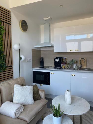 un salon avec un canapé et une cuisine dans l'établissement *Le Murmure de détente Guerlédan, à Mûr-de-Bretagne