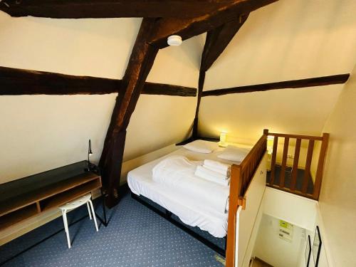 Cette petite chambre mansardée comprend un lit. dans l'établissement La Suite Marie Stuart Hypercentre, à Reims