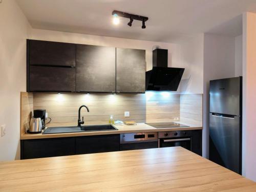 une cuisine avec des appareils en acier inoxydable et un comptoir en bois dans l'établissement Lac et Monts-Vue Montagne-Lac, à Charvonnex