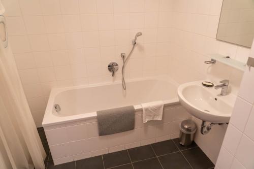 a bathroom with a bath tub and a sink at Andrea 3 by SMR Luxury Apartments inc Spa and near Gondola in Rauris
