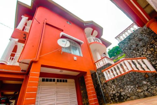 an orange building with a door and a balcony at Mountain View Villa in Freetown