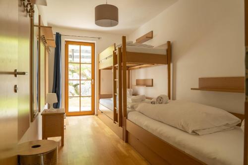 a bedroom with two bunk beds and a hallway at Andrea 1 by SMR Rauris Apartments inc SPA and near Gondola in Rauris