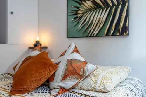a bed with pillows and a picture on the wall at Le Central Bleau 2 - Hypercentre in Fontainebleau