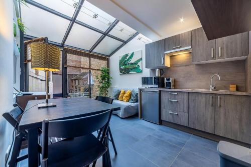 a kitchen and living room with a table and chairs at Le Central Bleau 2 - Hypercentre in Fontainebleau