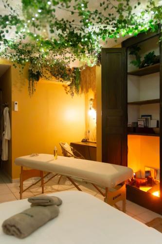 Cette chambre comprend un lit et une table avec des plantes. dans l'établissement L'aventurier - Jacuzzi Lounge & Massage, à Vierzon