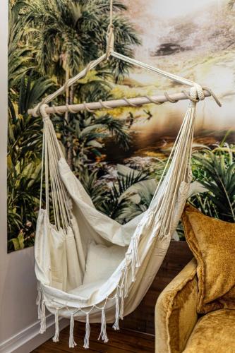 a swinging hammock in a living room with a painting at La Maison l Expérience - Cinéma Spa Proche Paris in Maisons-Alfort