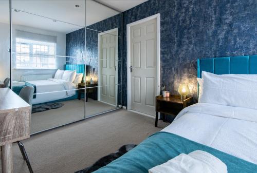 a bedroom with a large bed and a mirror at Comfortable 3-Bedroom House with Private Driveway in Bedford in Bedford
