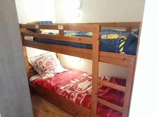 - une chambre avec 2 lits superposés et des draps rouges dans l'établissement Expérience Montagne Chamrousse Balcon Parking, à Chamrousse