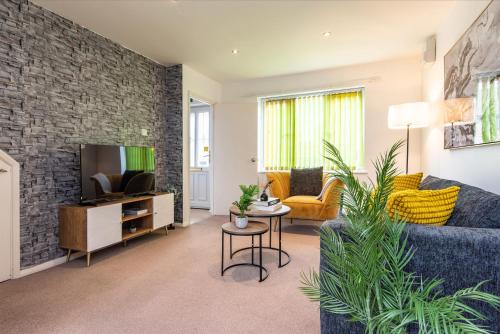 a living room with a blue couch and a tv at Comfortable 3-Bedroom House with Private Driveway in Bedford in Bedford