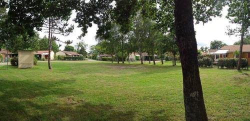 a park with a group of trees and houses at Cozy chalet des Moussaillons N99 - proche lac in Hourtin