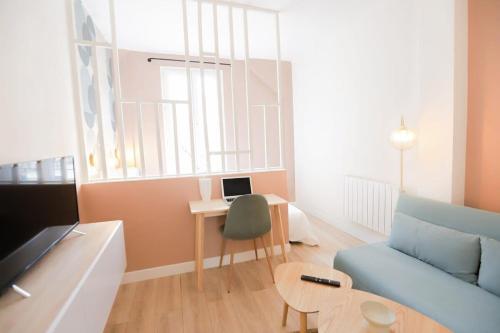 un salon avec un canapé et une table avec un ordinateur portable dans l'établissement Stadium Pink Loft 5min Rer near Paris, à Aubervilliers