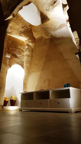 a living room with a table in a room with a ceiling at Il Vialetto Nei Sassi in Matera