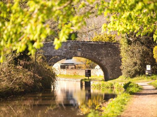 a stone bridge over a river with a building at 2 Bed in Brecon Town BN140 in Brecon
