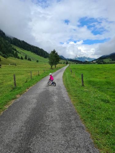 a little girl riding a bike down a road at Anna 1 by SMR Rauris Apartments - inc Spa and near Gondola in Rauris