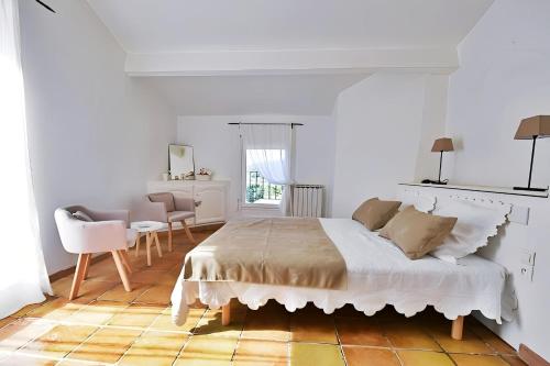 une chambre blanche avec un lit et une table dans l'établissement CASA-La Fontaine Maison Vacances Piscine, à Malaucène
