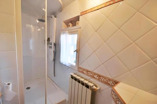La salle de bains est pourvue d'une douche à l'italienne et d'une cabine de douche en verre. dans l'établissement CASA-La Fontaine Maison Vacances Piscine, à Malaucène