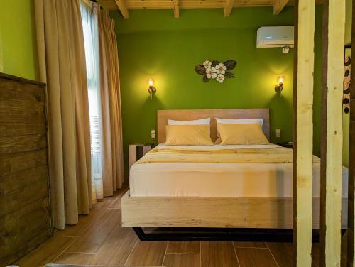 a bedroom with a bed with a green wall at Villa Vasil Mertiri in Himare