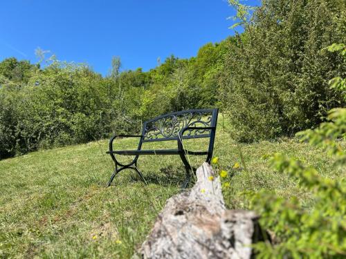 a bench sitting in the grass in a field at Chambre d'Hôtes du Domaine de Gargoris, Terrasse Privée & Piscine in Pont-du-Casse