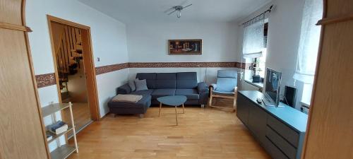 a living room with a blue couch and a television at Ferienhaus im Mansfelder Land in Wimmelburg