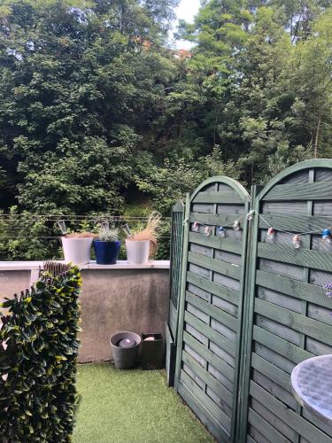 a pair of gates in a garden with potted plants at Citadin Cosy Nest Paris Area in Suresnes