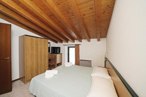 a bedroom with a bed and a wooden ceiling at Hotel La Pergola in Moniga