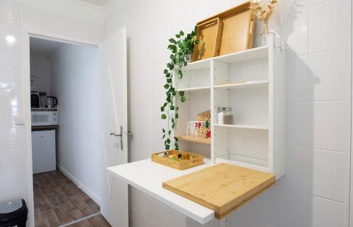 - une cuisine avec des murs blancs et un comptoir blanc dans l'établissement L Échappée Bellini - Proche Paris - 15min Airport, à Aulnay-sous-Bois