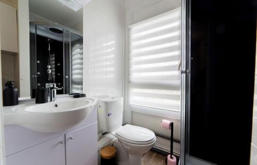 a white bathroom with a sink and a toilet at L Échappée Bellini - Proche Paris - 15min Airport in Aulnay-sous-Bois