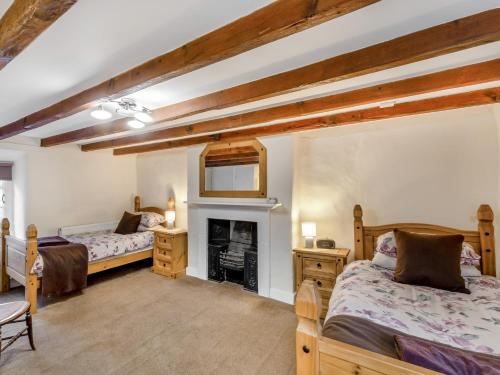 a bedroom with two beds and a fireplace at 2 Bed in Warkworth CN004 in Warkworth