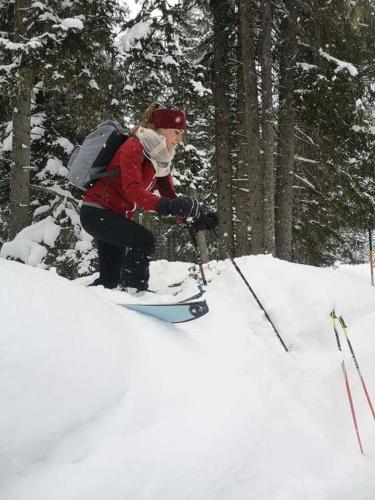 a woman on skis in the snow with a backpack at Isabella 2 by SMR Rauris Apartments - inc Spa and near Gondola in Rauris