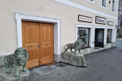 two statues of lions in front of a building at Isabella 2 by SMR Rauris Apartments - inc Spa and near Gondola in Rauris