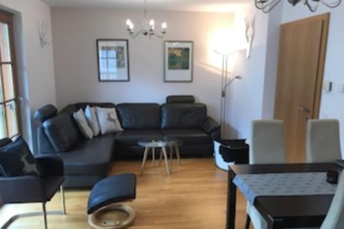 ラウリスにあるMartina 6 by SMR Rauris Apartments - inc Spa and near Gondolaの黒いソファとテーブルのあるリビングルーム