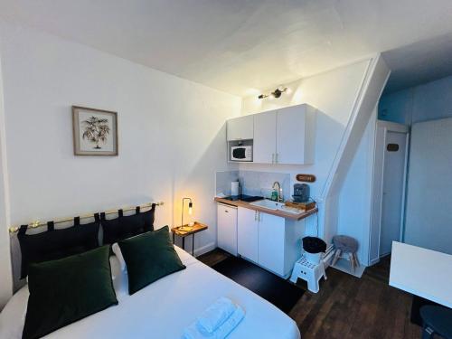 une chambre avec un lit et une petite cuisine dans l'établissement La Suite Briand - Hypercentre, à Reims