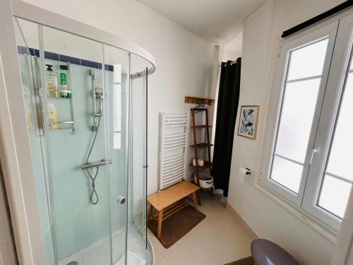 La salle de bains est pourvue d'une douche avec un banc et une fenêtre. dans l'établissement La Suite Briand - Hypercentre, à Reims